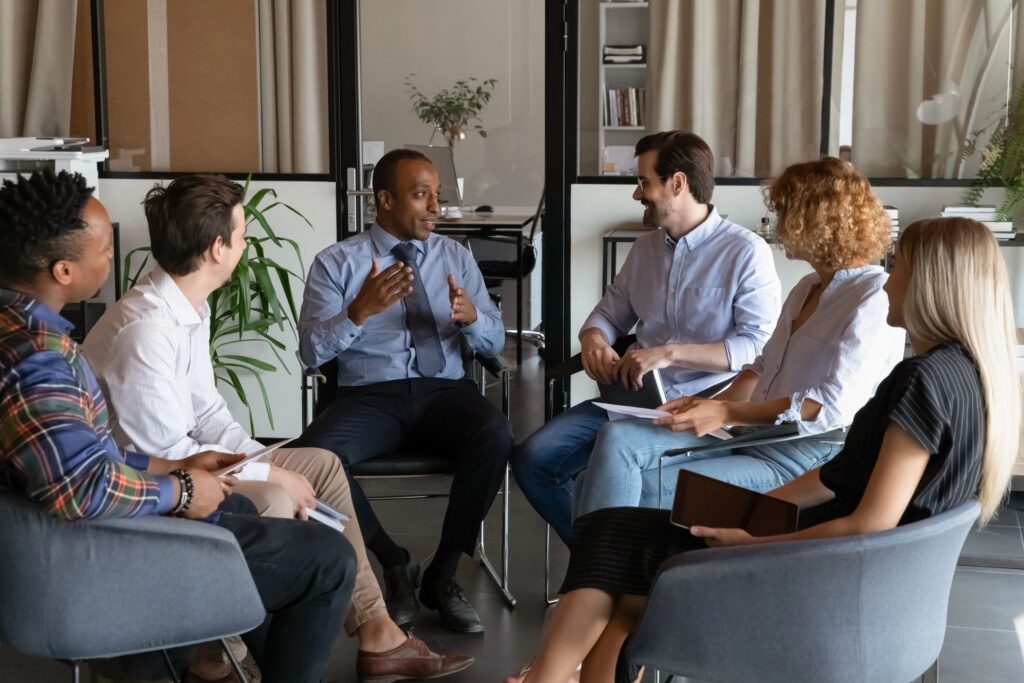 Multiethnic employees discuss ideas at team meeting